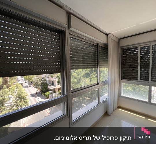 תריסים סגורים על חלונות זכוכית בחדר מואר